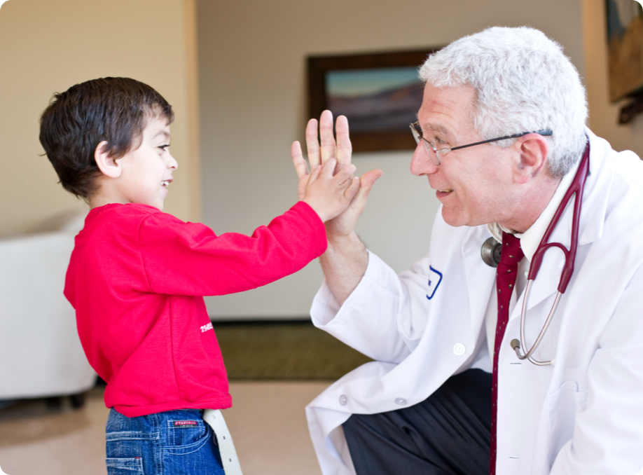 Photo of doctor giving a toddler with skeletal dysplasia a high five
